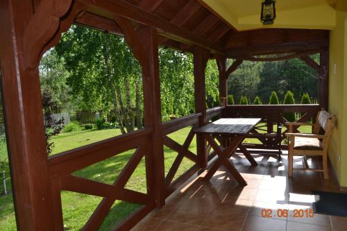 a screened in porch with a table and a picnic table at DOMEK LETNISKOWY NA MAZURACH in Wydminy