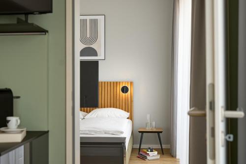 a bedroom with a bed with a wooden headboard at appartello - smarttime living Berlin in Berlin