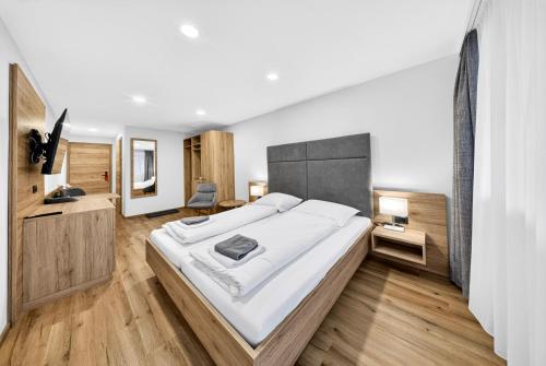 a large bedroom with a large bed and wooden floors at Schinagl Klaus in Klaus an der Pyhrnbahn