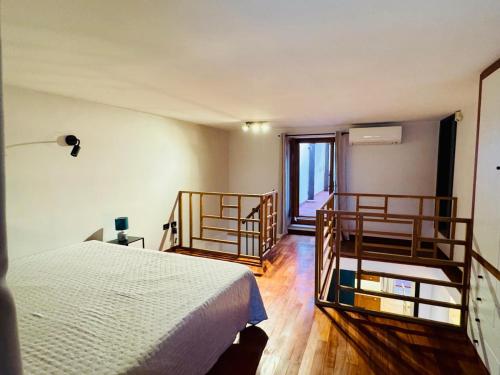 a bedroom with a bed and wooden floors and a window at APARTAMENT MAYA - Julia Vieste in Vieste