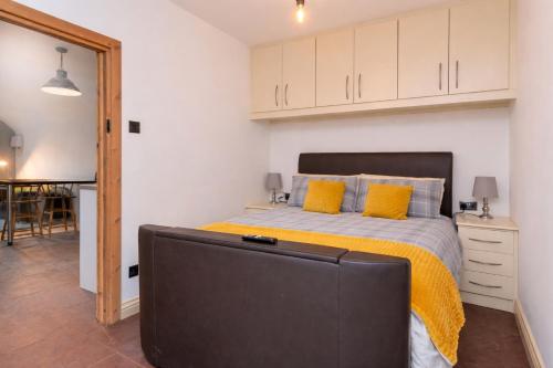 a bedroom with a bed with yellow pillows and a tv at The Shed in Coventry