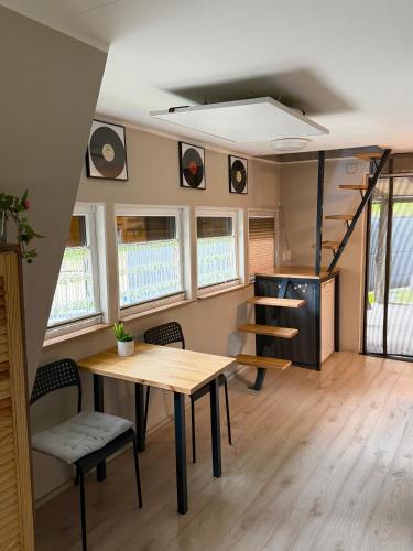 a tiny house with a table and chairs and a staircase at Domek Kitara in Skorochow
