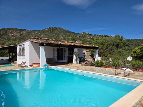 a villa with a swimming pool in front of a house at Villa Altora in Nuragheddu