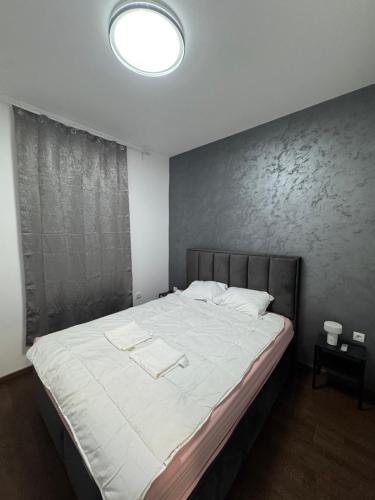 a bedroom with a large bed with white sheets at Apartman S in Vrnjačka Banja