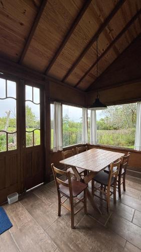 a dining room with a wooden table and chairs at Casinha à beira do arroio in Pelotas