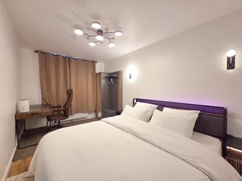 a bedroom with a bed and a desk and a chair at Suite Design Balnéo - Lit King size - Garage privé in Tournai