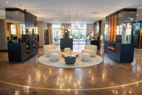 a lobby with chairs and a table in a building at Best Western Plus Delta Park Hotel in Mannheim