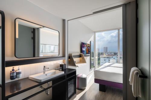 a bathroom with a sink and a large window at YOTEL Bangkok Sukhumvit in Ban Nong Chaeng