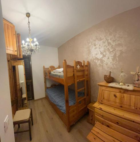 a room with a bunk bed and a table at Appartamento Tulipano in Nevegal