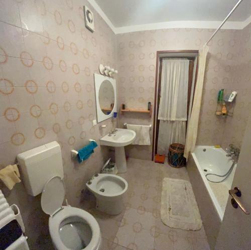 a bathroom with a toilet and a sink at Appartamento Tulipano in Nevegal