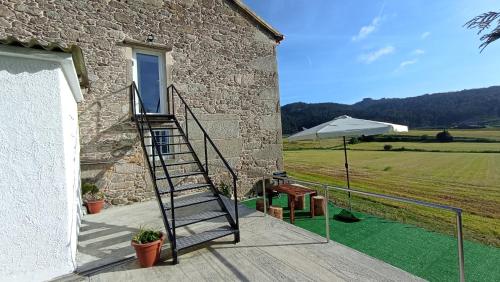 a stairway leading up to a building with a field at Brisa do Mar in Laxe