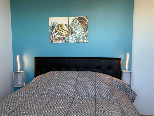 a bed in a blue room with two candles at La Rose des Sables in Tréffiagat