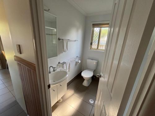 a white bathroom with a toilet and a sink at Longreach Starlight Cabins - Boutique Outback Accommodation in Longreach