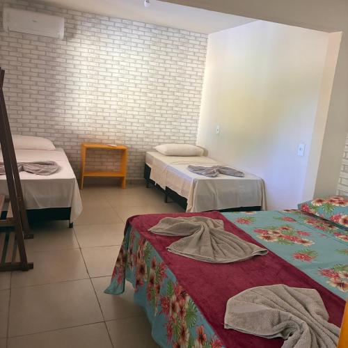 a room with two beds with towels on them at Morada 1000 - Pousada in Frutal