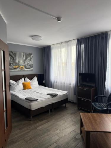 a hotel room with a bed and a television at AtmosferA in Bydgoszcz