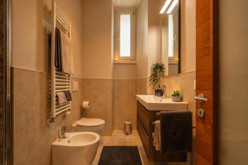 a bathroom with a toilet and a sink and a mirror at Marconi Home in Trieste
