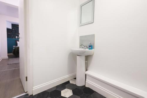a bathroom with a sink and a mirror at Studio - Kitchen - Parking - Ideal for Contractors in Swansea