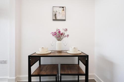 a table with a vase of flowers on it at Studio - Kitchen - Parking - Ideal for Contractors in Swansea
