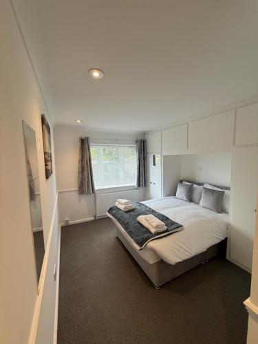 a bedroom with a large bed with a window at Windsor side in Datchet