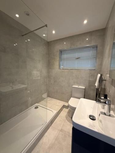 a bathroom with a tub and a toilet and a sink at Windsor side in Datchet