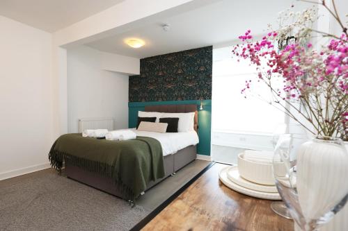 a bedroom with a bed and a vase of flowers at Studio - Kitchen - Parking - Ideal for Contractors in Swansea