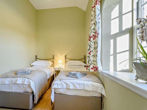 two twin beds in a room with a window at 2 Bed in Hawick oc-86021 in Hawick
