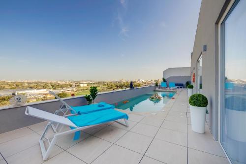 a balcony with a chair and a pool on a building at Superlative 3BR Penthouse, Private Pool and Views in Hal Ghaxiak
