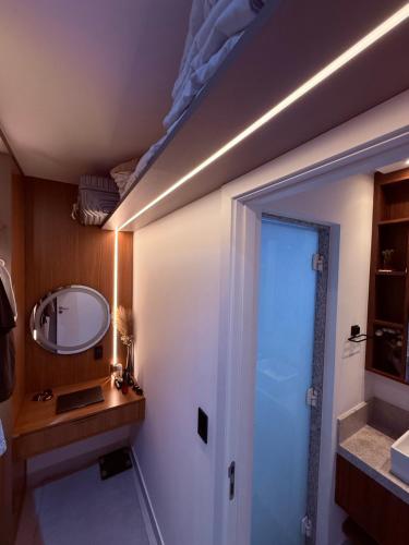 a bathroom with a sink and a mirror and a door at Apartamento top em Vila Velha in Vila Velha
