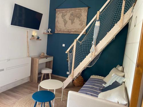 a room with a net and a couch and a table at la passerelle du couchant in Langlade