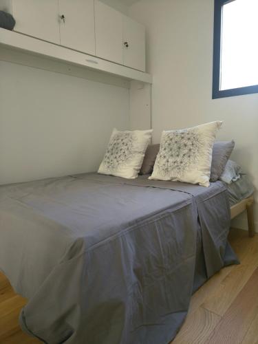 a bed in a white room with pillows on it at A Estrenar Estudio las Cañitas in Buenos Aires