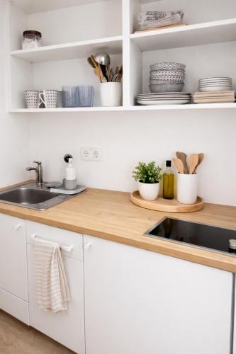 a kitchen with white cabinets and a sink at Ekoviki2 in Kranj
