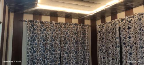 a bathroom with a shower curtain in a room at BAKSHI lodge in Pahalgām