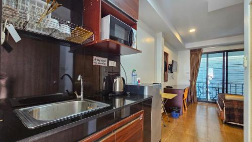 a kitchen with a sink and a microwave at Smyrna in Pattaya