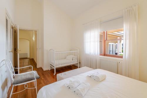 a white bedroom with two beds and a window at Villa Aqueduto in Póvoa de Varzim
