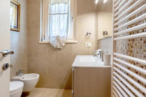 a bathroom with a sink and a toilet and a window at Bardolino Golden Hill in Bardolino