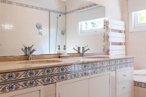 a bathroom with two sinks and a mirror at Villa Aqueduto in Póvoa de Varzim