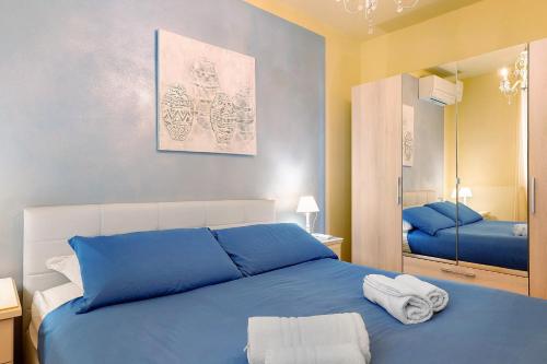 a bedroom with a blue bed with towels on it at Bardolino Golden Hill in Bardolino