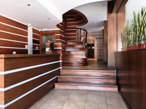 a staircase in a lobby with wood paneling at Hotel Don Carlos in Villa Gesell
