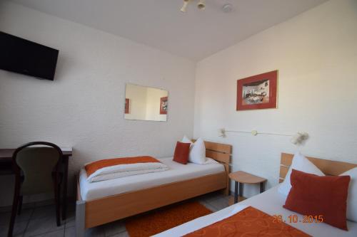 a hotel room with two beds and a desk at Hotel & Restaurant Main Taunus in Hochheim am Main