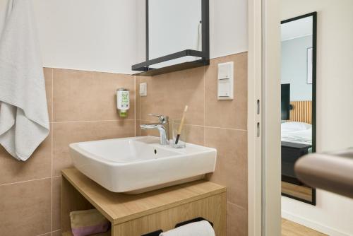 a bathroom with a sink and a mirror at appartello - smarttime living Berlin in Berlin