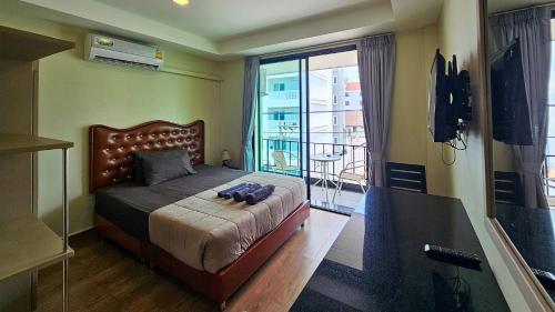 a bedroom with a large bed with a balcony at Smyrna in Pattaya
