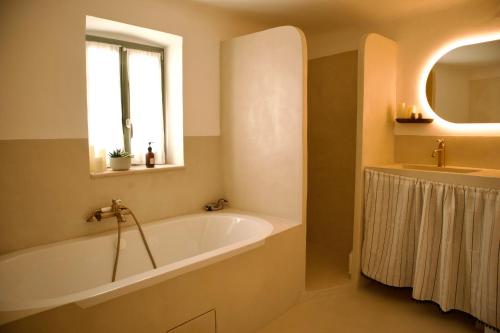 a bathroom with a tub and a window and a sink at Vue Lac avec Terrasse Privée - "Lani" - Ola Verdon in Bauduen