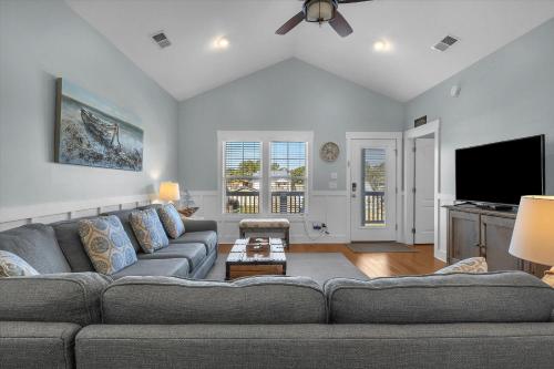 a living room with a couch and a flat screen tv at All Summer Long by Oak Island Accommodations in Oak Island