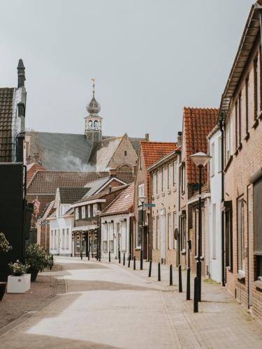 an empty street in an old town with a clock tower at Oysterduinen - Resort Yerseke in Yerseke