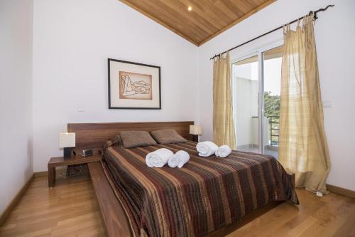a bedroom with a bed with two towels on it at Casa Oliveira by Algarve Holidays in Loulé