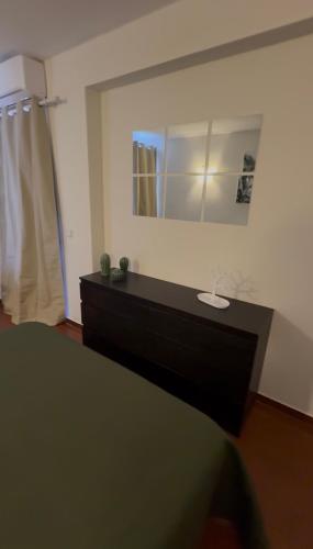 a bedroom with a dresser and a mirror at Apartamento Oura - Albufeira in Bicas