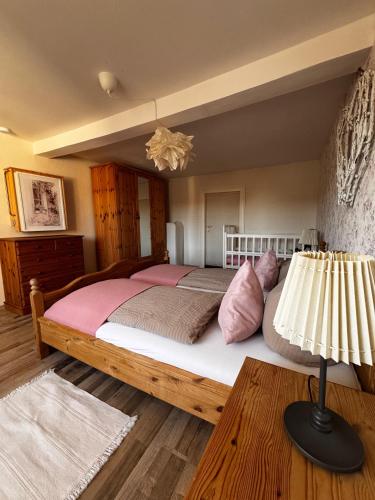 a bedroom with a large bed with pink pillows at Ferienhaus Kaline in Grebenhain