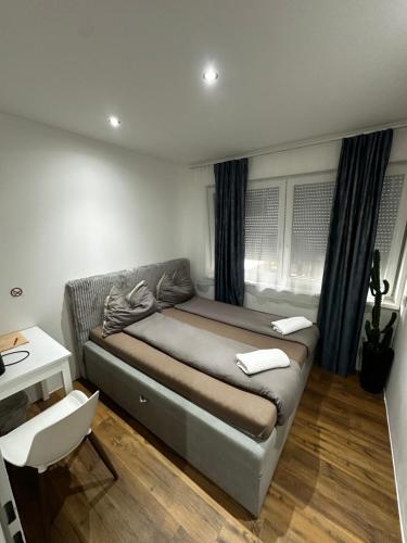 a bedroom with a bed and a table and a desk at Zimmervermietung Wels 2 in Wels