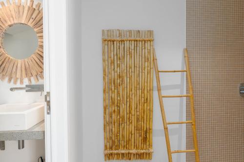 a bathroom with a bamboo shower curtain and a ladder at Unmei by LovelyStay in Caniço