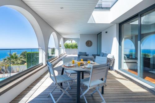 a dining room with a table and chairs on a balcony at Unmei by LovelyStay in Caniço